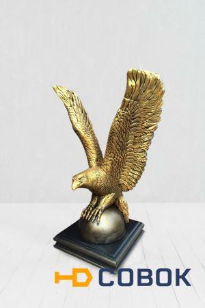 Фото Скульптура орла на шаре в золотом цвете